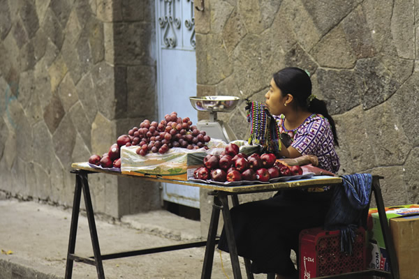 Woman in traditional attire selling fruit in Santiago Atitlan.