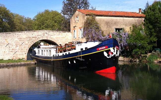 The Anjodi cruising under a bridge in France.