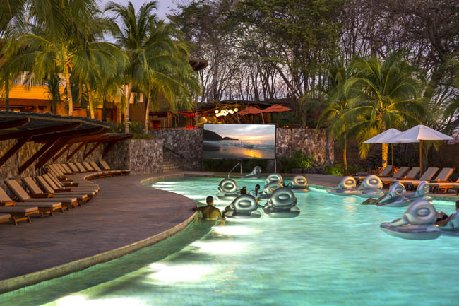 Guests can relax as they watch a movie from the pool.