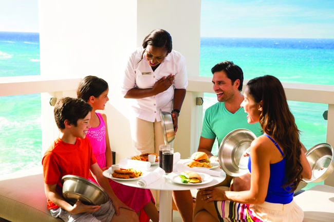 A butler serving a family in their suite at Hyatt Ziva Rose Hall.