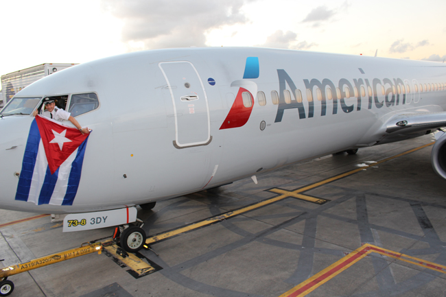 A pilot waves the Cuban flag from an American Airlines plane.