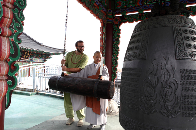A guest participating in Myogaksa Temple's evening bell striking ritual in Seoul.