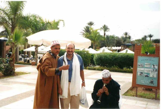That's Scott in Morocco in 1999. Of the image, he says, "don't judge the danger because the snake around my neck was small. What you could not see was the Cobra at my feet that was way too close!"